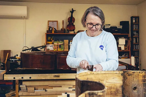 Chantal Van Lierop arbeitet an ihrer Werkbank an einem Kontrabass