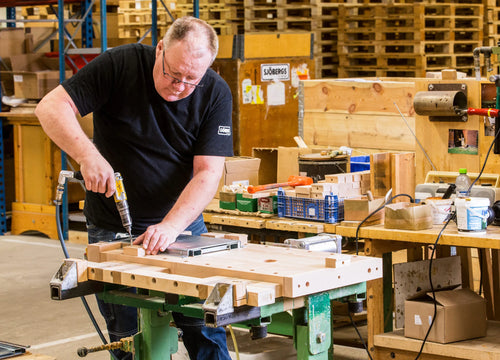 Ein Mitarbeiter montiert eine Werkbank in der Sjöbergs Fabrik